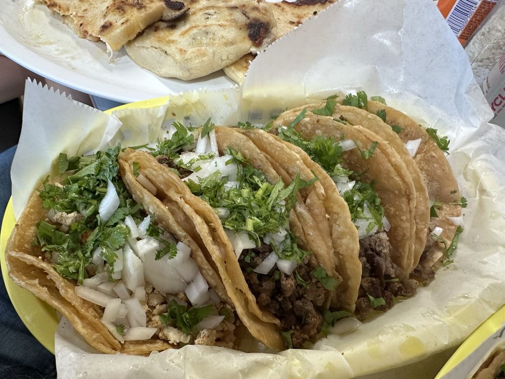 A basket of street tacos and pupusas